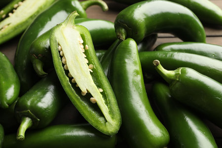 Fresh jalapeno peppers on table, closeup. Whole and cut
