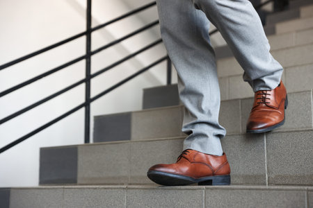 Man walking down stairs indoors, closeup view