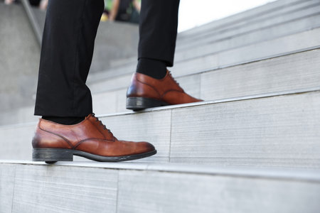 Man walking up stairs outdoors, closeup view