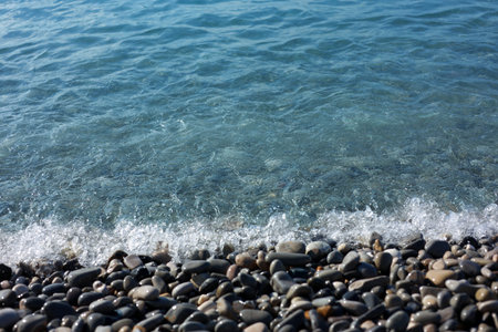 Beautiful view of wavy sea and pebbles on beach