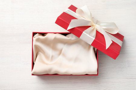Open gift box with beautiful lid on white wooden table, top viewの写真素材