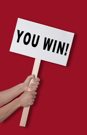 Man holding sign with phrase You Win against dark red background, closeupの写真素材