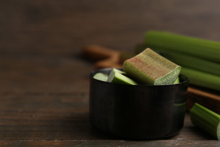 Cut fresh rhubarb on wooden table, closeup. Space for textの写真素材