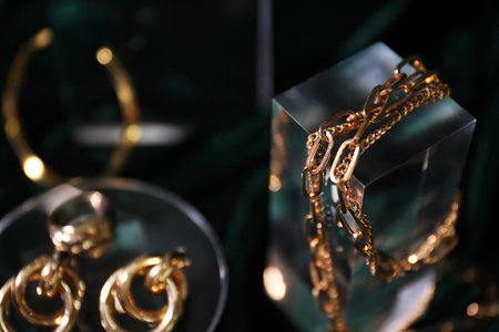 Stylish presentation of gold jewelry on dark background, selective focus. Space for textの写真素材