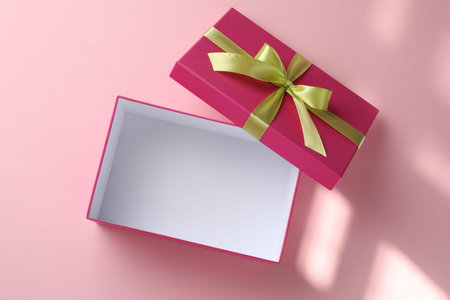 Open gift box with beautiful lid on pink background, top viewの写真素材