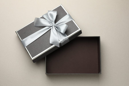 Open gift box with beautiful lid on light gray background, top view