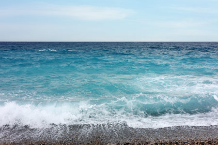Beautiful view of wavy sea and pebbles on beach