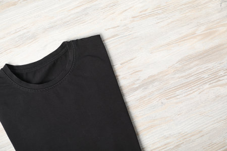 Black t-shirt on wooden table, top view. Mockup for designの写真素材