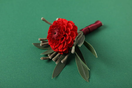 Stylish boutonniere with flower on green background, closeup