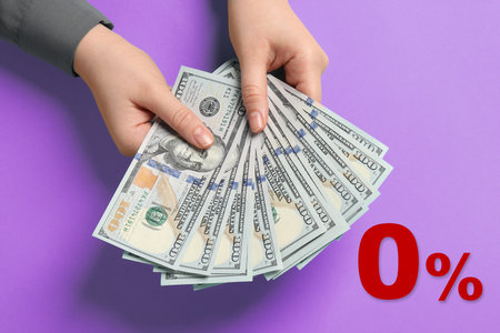 Zero percent commission. Woman holding dollars on violet background, closeup