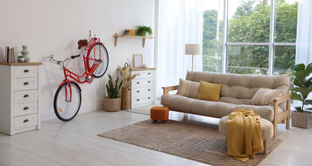 Red bicycle, furniture and houseplants in roomの写真素材
