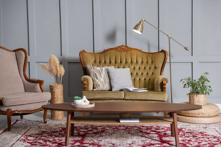 Soft sofa, table, armchair and lamp near gray wall in living room. Interior designの写真素材