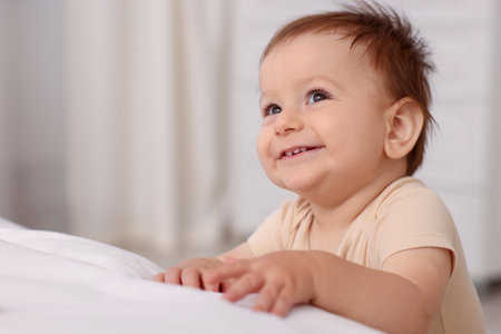 Cute little baby near bed at home