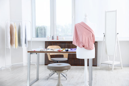 Female mannequin with fabric and sewing supplies in atelierの写真素材