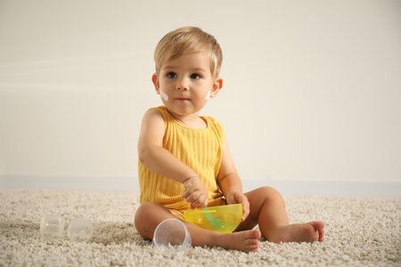 Cute baby with cream on his body playing at home