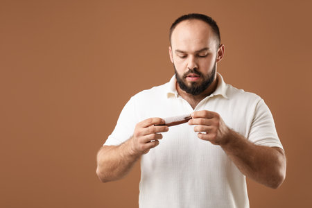 Baldness problem. Worried man taking his lost hair from comb on brown background. Space for textの写真素材