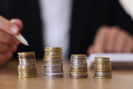Woman counting coins at wooden table indoors, selective focus