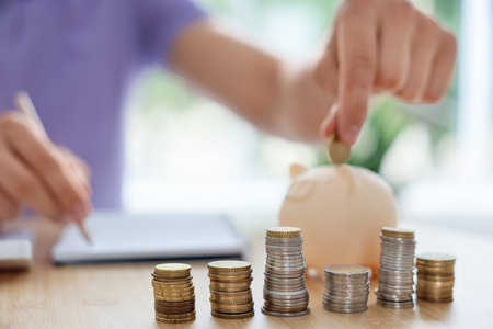 Man putting coin into piggy bank at wooden table indoors, selective focus