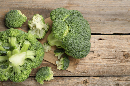 Fresh raw broccoli on wooden table, above view. Space for text