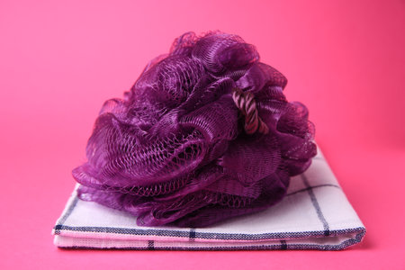 Purple shower puff and towel on pink backgroundの写真素材