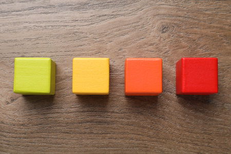 Colorful cubes on wooden table, flat lay