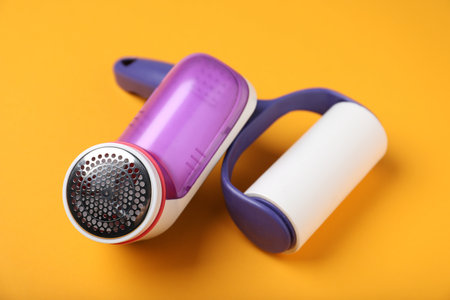 Lint roller and fabric shaver on orange background, closeupの写真素材