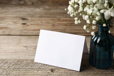Blank card and flowers on wooden table, closeupの写真素材