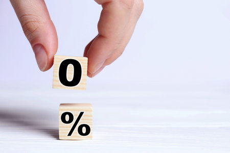 Woman putting cube with 0 onto another one with percent sign on table, closeup