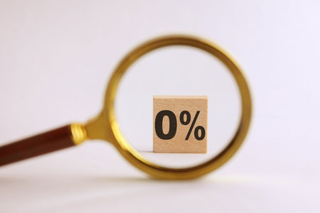 Cube with 0% on table. View through magnifying glassの写真素材