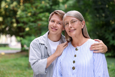 Family portrait of happy mother and her son outdoors. Space for textの写真素材