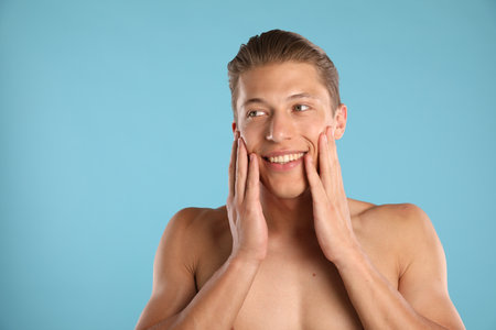Young man on light blue background, space for textの写真素材