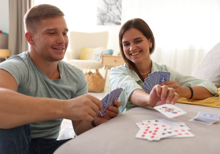 Man and woman playing cards at homeの写真素材