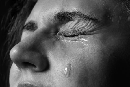 Sad woman crying on dark background, closeup. Black and white effectの写真素材