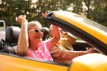 Senior couple enjoying cabriolet ride in city, selective focusの写真素材