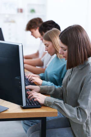 Students taking online exam indoors, selective focus