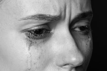 Sad woman crying on dark background, closeup. Black and white effectの写真素材