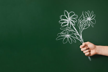 Happy teacher's day. Man near chalkboard with drawn bouquet of flowers, closeup. Space for textの写真素材