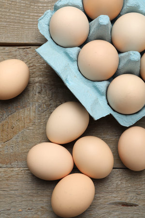 Raw eggs on wooden table, top view