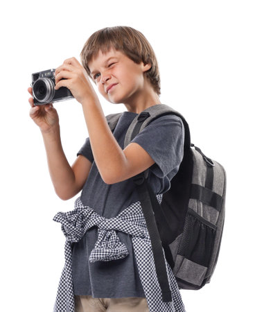 Choice of profession. Little boy with camera and backpack pretending to be a photographer on white backgroundの写真素材