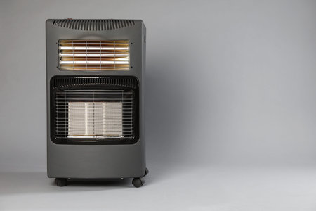 One electric heater on gray background. Space for text