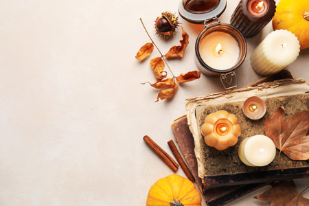 Different burning candles, books and autumn decor on light table, flat lay. Space for textの写真素材