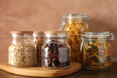 Glass jars with different products on wooden tableの写真素材