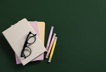 Happy teacher's day. Notebook, stationery and glasses on green background, flat lay. Space for textの写真素材