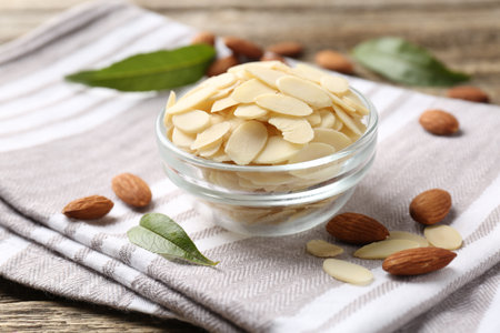 Fresh almond flakes and whole nuts on table, closeupの写真素材