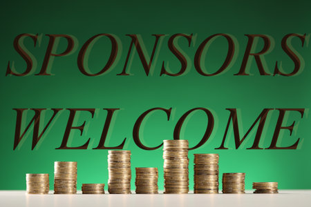 Stacked coins on table against green backgroundの写真素材