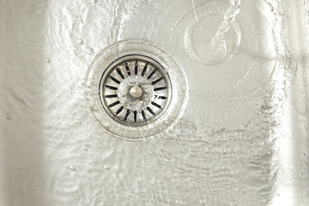 Water going down sink drain, top view