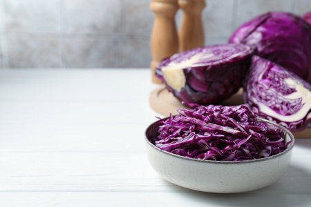 Whole and cut fresh red cabbages on white wooden table, space for textの写真素材