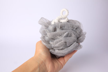 Woman holding gray mesh sponge on white background, closeupの写真素材