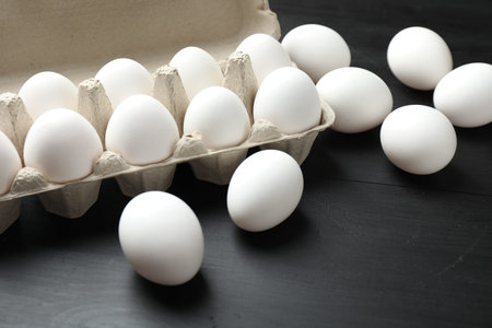 Eggs on black wooden table, closeup