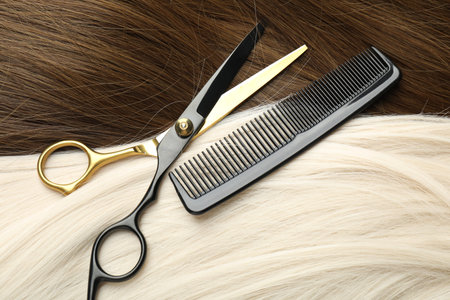 Scissors and comb on beautiful hair in different colors, above view